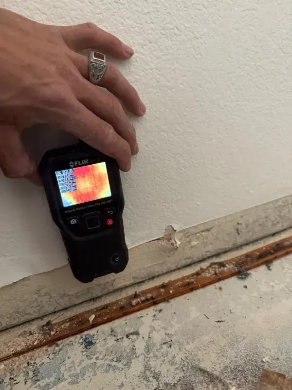 A thermal camera checking a wall where the baseboard came off, moisture mapping for Owasso homes