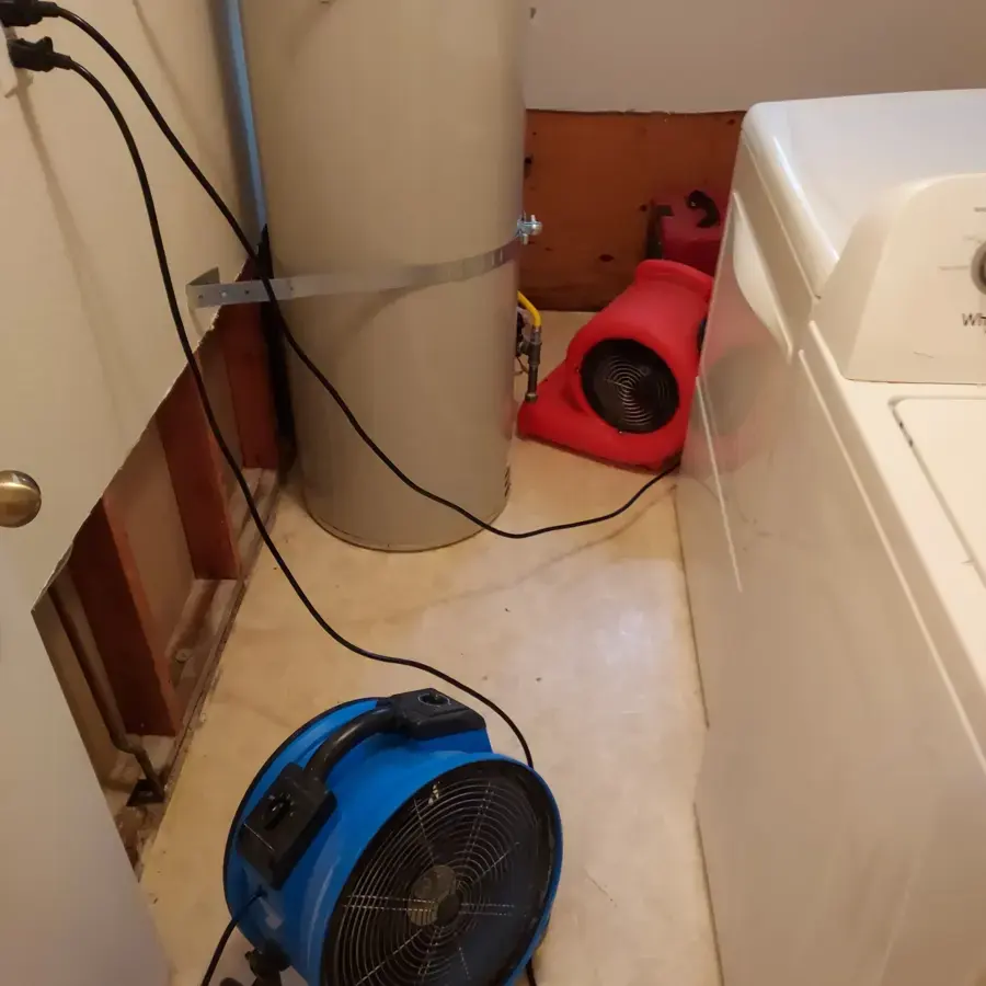 Air movers drying a laundry area with the wall opened behind the washer, an Owasso appliance leak dry-out