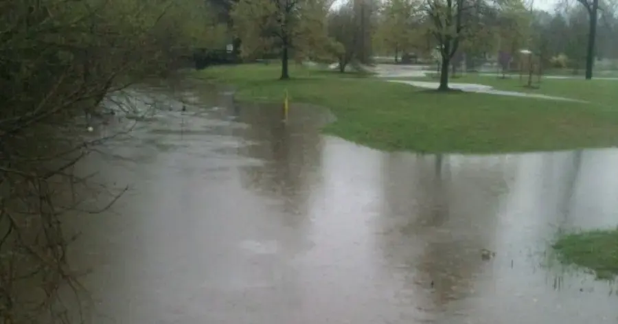 Creek water spreading over a park lawn after heavy rain, the kind of creek flooding Collinsville sees