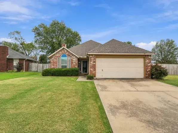 A brick ranch house with a two-car garage, a common style in Owasso subdivisions