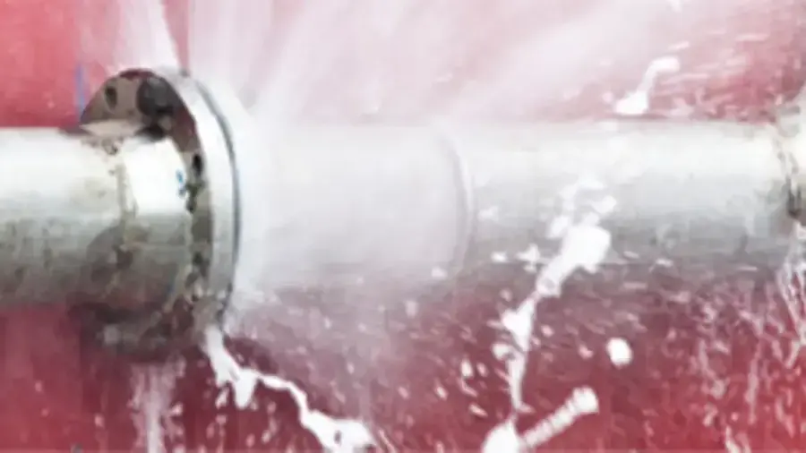 Water spraying from a failed joint on a metal supply pipe, the burst pipe damage Owasso homes see